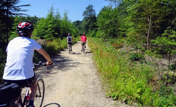 3 cyclists riding on gravel track taken from the back.jpg
